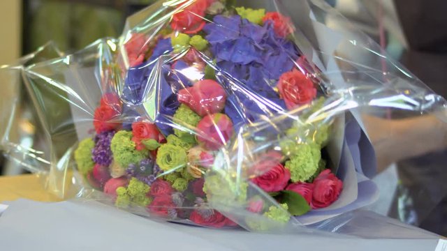 Florist pack bouquet of flowers in transparent packaging