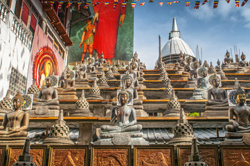 Statues of the Buddha in the lotus position, Gangaramaya Buddhist Temple, Colombo, Sri Lanka.