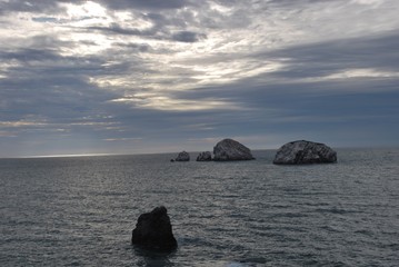 Fototapeta na wymiar Atardecer en playa con rocas en la costa