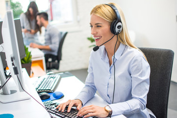 Beautiful business woman with headset working in office