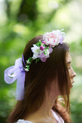 Naklejka premium Pretty young woman in a white dress walking in the forest