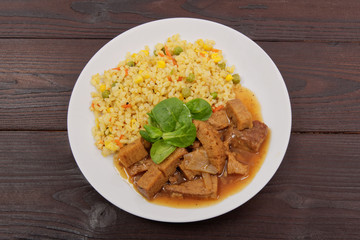 Tempeh with tomato sauce and millets on a table