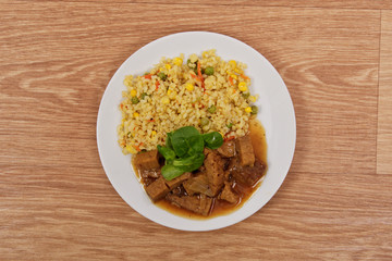 Tempeh with tomato sauce and millets on a table