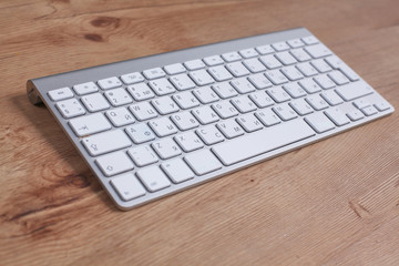 Modern aluminum keyboard on the wooden table in the office