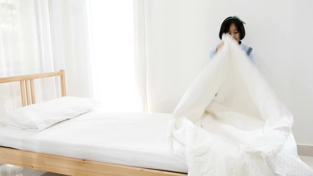4K Asian girl cleaning bed room, making bed