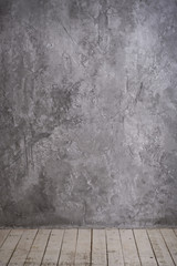Bright vintage loft interior with wooden floor, textured aged grey plaster concrete on the wall. Empty