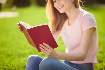 Girl reading a book in the Park. close up