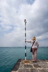 Girl on a pier looking out to sea on a windy day