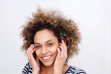 Close up attractive young african american woman listening to music against white background