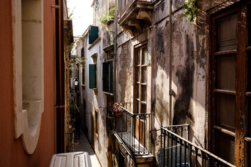 Fototapeta na wymiar sicilian shutters in a very narrow street, in the morning light