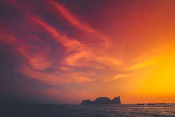 Naklejka na ściany i meble Spectacular sunset over the Indian Ocean next to the exotic Phi Phi Islands in the Kingdom of Thailand. Amazing golden and scarlet color combination. Perfect background.