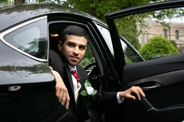 Groom arrives by car at village church on his wedding day