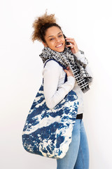 young black woman with bag and cellphone against white background