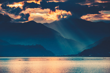 The amazing fairy tale sunset over the freshwater Phewa Lake. The breathtaking colorful cloudy sky. The main tourist attraction of Pokhara city in Nepal.