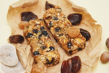 Granola Bars on Craft Paper Background with Cereal Nuts and Dried Fruits. diet, Fitness and Healthy Food Concept.