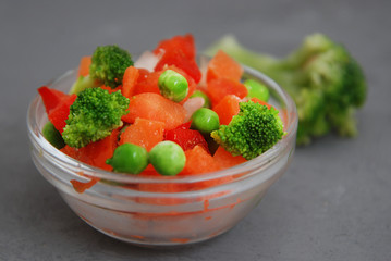 Frozen Colorful Vegan Healthy Vegetables. Brocolli, Carrots, Peas, Pepper. vertical Image. Gray...