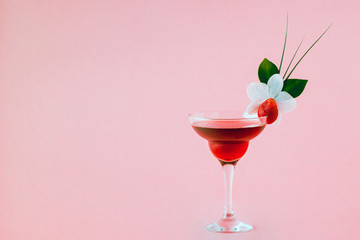Mocktail decorated with strawberry, flower and tropical leaves.