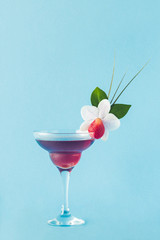 Mocktail decorated with strawberry, flower and tropical leaves.