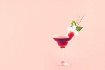 Mocktail decorated with strawberry, flower and tropical leaves.