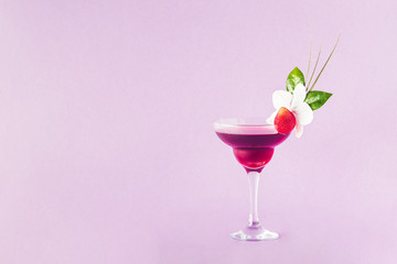 Mocktail decorated with strawberry, flower and tropical leaves.