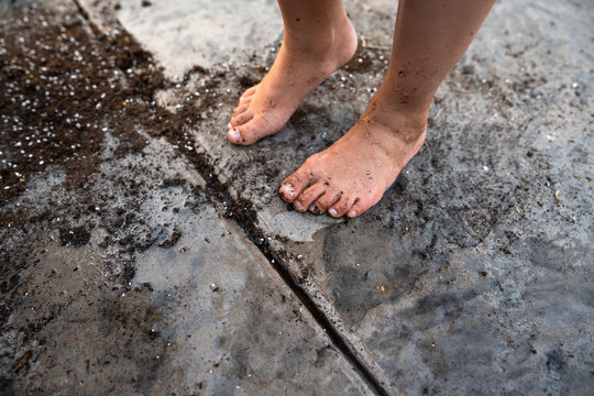 Barefoot girl with dirty feet