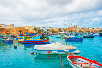 Fototapeta na wymiar Luzzu boats Marsaxlokk harbor in bay Mediterranean sea Malta