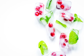 ice cubes with red berries and mint top view white background mo