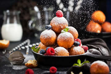 Fresh delicious homemade cottage cheese ball donuts with powdered sugar on dark background