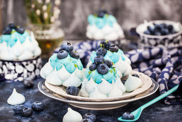 Delicious blueberry Pavlova meringue cakes decorated with cream and fresh berries