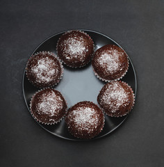 Homebaked Chocolate Muffins for Easter with colored Conffeti. Dark Background. Sweet Dessert for Breakfast.
