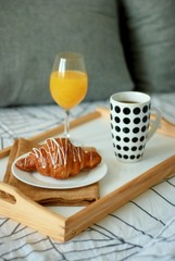 close up Breakfast in bed. Coffee and Croissants White Chocolate Food. Cup of Coffe or Tea. Morning light.