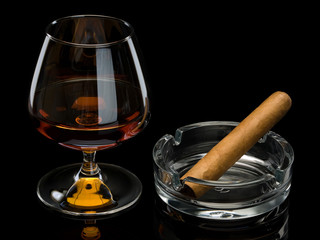 Cognac and cigar in a glass ashtray
