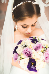 Luxury bride in white dress posing while preparing for the wedding ceremony