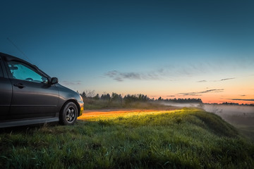 Fototapeta na wymiar Car and light of headlights at sunset outdoors