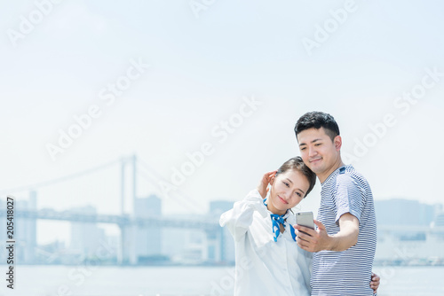 スマートフォンで写真を撮るカップル 自撮り Wall Mural Chachamal