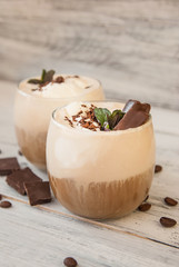 Iced Mocha Coffee with Whip Cream, Summer Drinking times. Coffee Beans. rustic textured Wooden Background. Mint Leaves