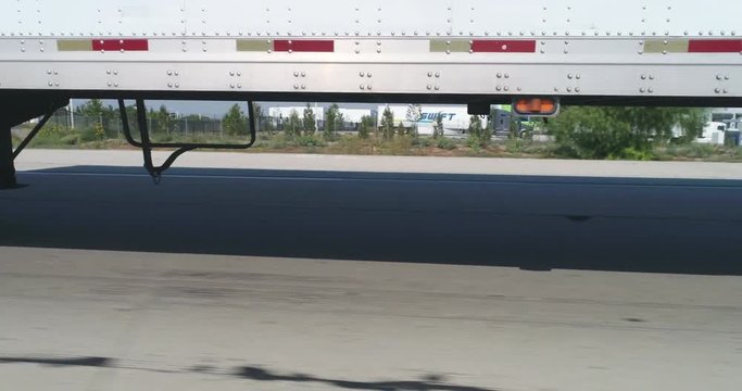 pov shot of semi trailer truck traffic on highway. Truck and camera by side - August 2017: Interstate 15, California, US