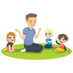 Young male kindergarten teacher explaining lesson to attentive kids sitting on floor