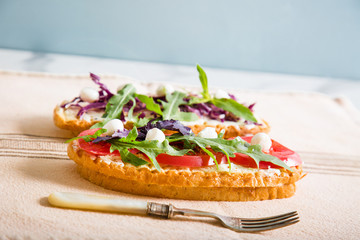 Toast with tomato, arugula, rucola, mozarella cheese, bread and greens