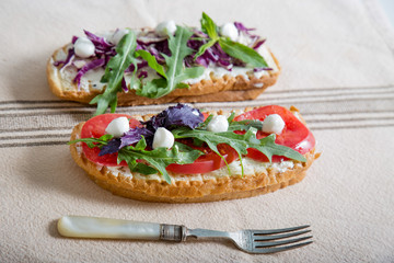 Toast with tomato, arugula, rucola, mozarella cheese, bread and greens