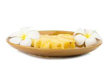 Pineapple piece on dish with flower isolated on white background