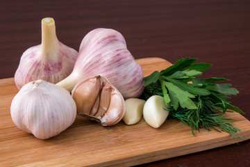 Young and old garlic at the table. dark background
