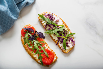 Toast with tomato, arugula, rucola, mozarella cheese, bread and greens