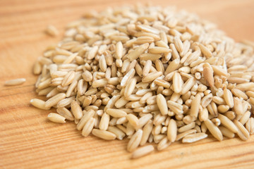 heap raw oats in wooden background. Close up.