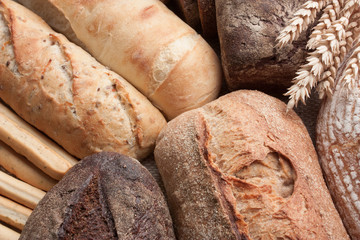 Food background of freshly baked bread with ears of wheat.