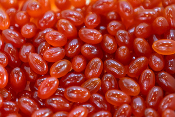 Background - close up of countless red colourful medicine  pills with shallow depth of field, bokeh