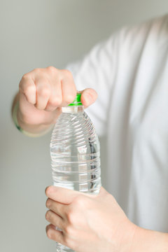 A woman try to open drinking water bottle.