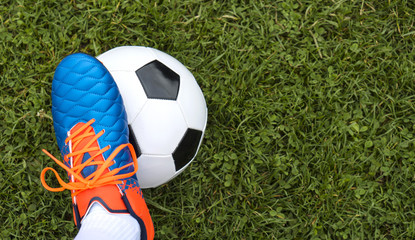 Fototapeta na wymiar Football player and ball on a grass close-up