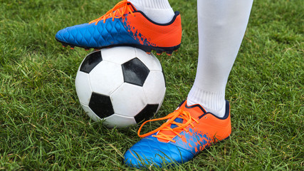 Football player and ball on a grass close-up