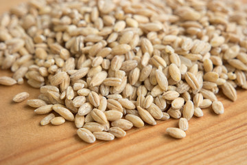 pile of barley pearl in wooden background.
